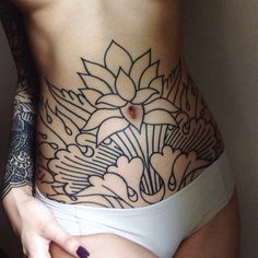 a woman's stomach with tattoos on it