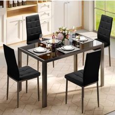 a dining room table with four chairs and plates on the table in front of it