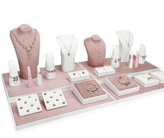 a table with jewelry on it including necklaces, rings and bracelets in white boxes