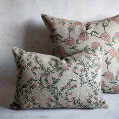 two floral pillows on a white surface