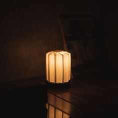 a lit candle sitting on top of a wooden table