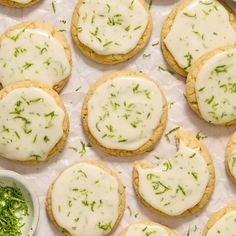 there are many cookies with white icing and green sprinkles on them