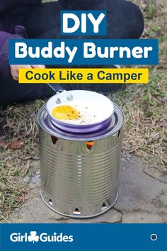 a person sitting on the ground next to a bucket with food in it and text that reads diy buddy burner cook like a camper