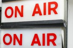 two red and white signs on the side of a building that says on air on air