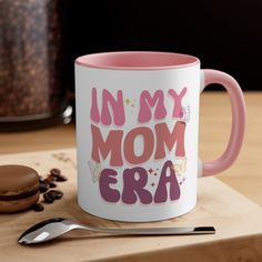 a pink and white coffee mug with the words in my mom era written on it