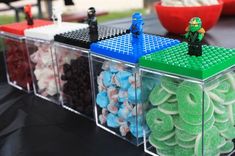 some legos are sitting in plastic containers on a table