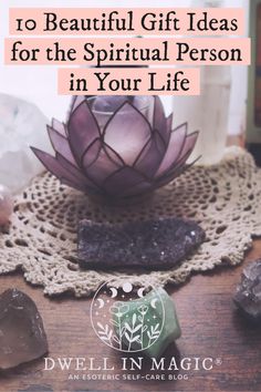 a purple flower sitting on top of a wooden table next to rocks and other items