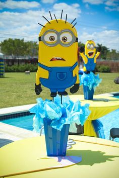 two small yellow and blue decorations in front of a pool