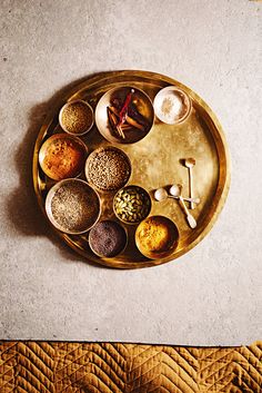 a golden tray with different types of spices on it