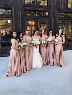 a group of women standing next to each other in front of a building with windows