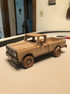 a wooden toy truck sitting on top of a white counter next to a clock and mirror