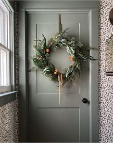 a green door with a wreath hanging on it