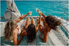 three beautiful women sitting on the back of a boat