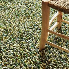 a wooden chair sitting on top of a carpet covered in lots of green and yellow stuff