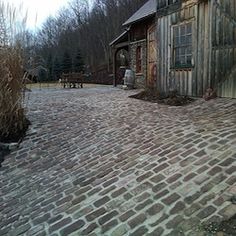 an old brick road leading to a building