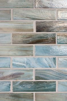 a close up view of some blue and grey tiles on the wall in a bathroom