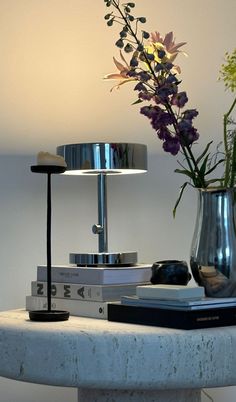 a table topped with books and a vase filled with flowers sitting on top of it