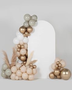 an arch with gold and white balloons on it, next to some other balloon decorations