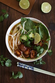 a white bowl filled with meat and veggies on top of a wooden table