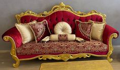 a red and gold couch with pillows on it