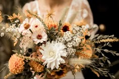 a woman holding a bouquet of flowers in her hands