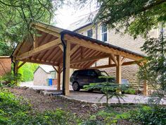 a car is parked under a wooden carport