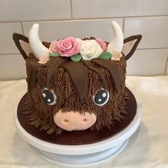 a cake decorated to look like a cow with horns and flowers on it's head