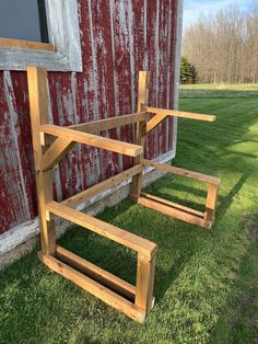 two wooden benches sitting in front of a red barn