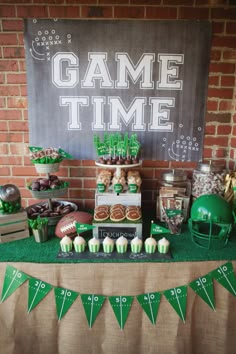 a football themed party with game time food and decorations on the table, along with green cupcakes