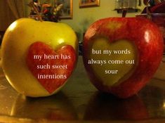 two apples with words written on them sitting next to each other in front of a mirror