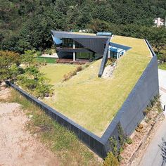 an aerial view of a green roof on a house in the hills above it,