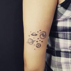 a woman with a tattoo on her arm that has planets and sun in the sky