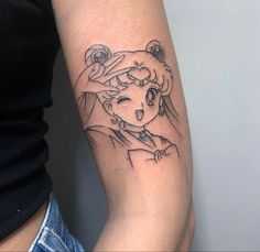 a woman's arm with a tattoo on it that has an image of a cartoon character