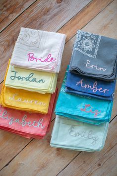 four different colored towels with the names of bride and groom on them sitting next to each other