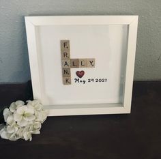 a white frame with scrabbles and flowers in it