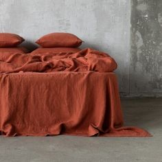 an orange bed with two pillows and a sign on the floor next to it that says european flax