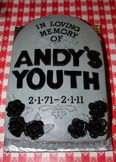 a cake that is on top of a red and white checkered tablecloth with the words, in loving memory of andy's youth