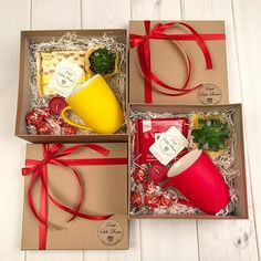 two boxes filled with different types of items and wrapped in red ribbon on top of a white wooden floor