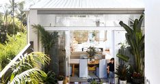 an outdoor dining area with potted plants in the foreground and a view of water