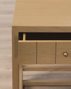 a wooden table with two drawers on each side and an open drawer at the top