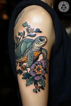 a woman's arm with a turtle and flowers on it