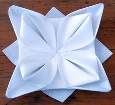 an origami flower sitting on top of a wooden table