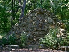 an old stone building surrounded by trees and benches