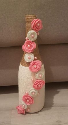 a wine bottle decorated with pink and white flowers