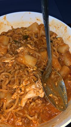 a white bowl filled with noodles and meat