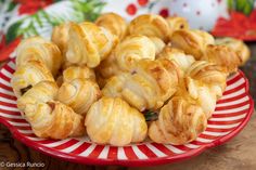 a plate full of croissants sitting on top of a red and white striped plate