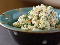 a blue bowl filled with food on top of a table