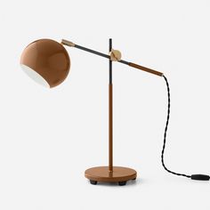 a desk lamp with a cord attached to it and a light on the top of it