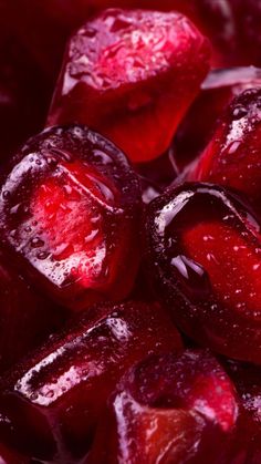 closeup of red fruit with ice on the top and water droplets all over it