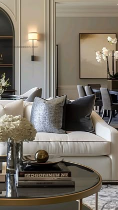 a living room filled with lots of furniture and flowers on top of a coffee table